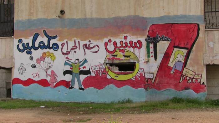 بالجرافيتي.. “الأسمر” يوثّق معاناة السوريين على الجدران المدمّرة