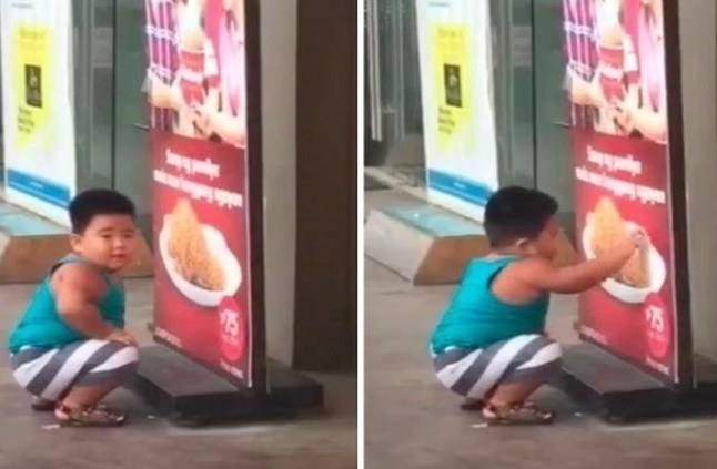 طفل جائع يحاول تناول الدجاج من ملصق إعلاني-فيديو