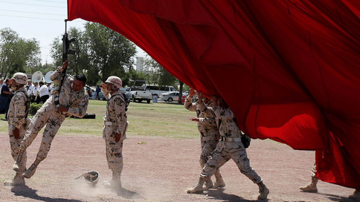 México: Un soldado vuela por los aires tras enredarse con una bandera (VIDEO)