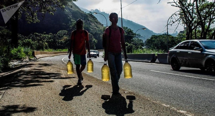Apagón obliga a habitantes de Caracas a recoger agua de las laderas de una montaña