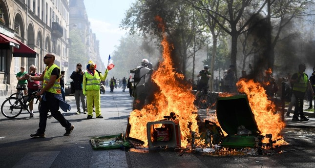 Masked demonstrators clash with riot police in Paris