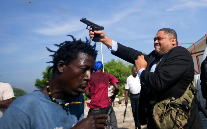 Photographer shot as senator pulls his gun on protesters outside Haiti Senate