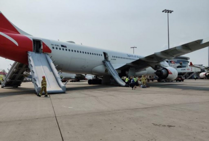 Passengers evacuate Qantas plane via emergency slides at Sydney airport  