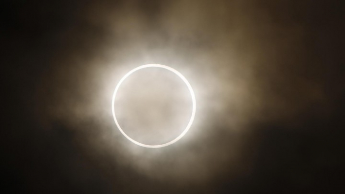 Menschen bestaunen ringförmige Sonnenfinsternis