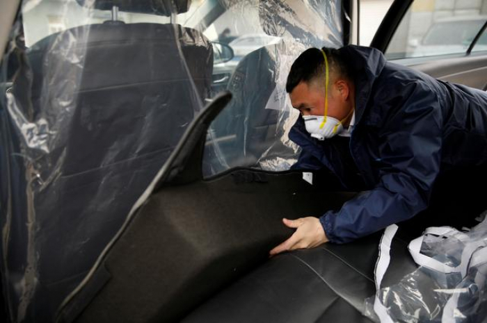 Amid virus, Chinese ride-sharing cars install added layer of protection