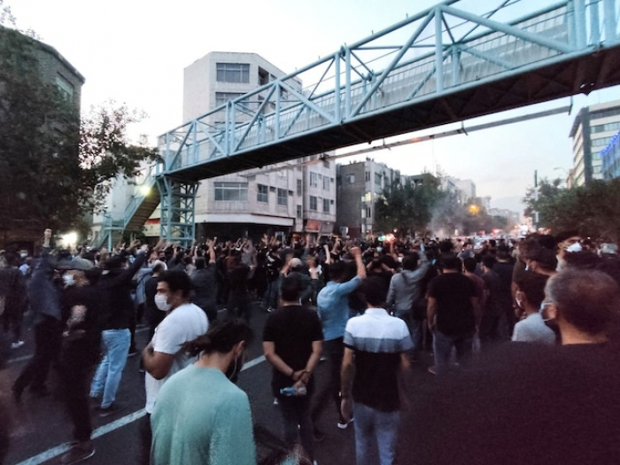 Iranian protesters torch police stations as unrest over woman