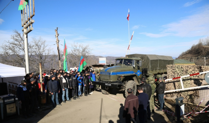   Otra caravana del contingente pacificador ruso pasa por la carretera donde se lleva a cabo la protesta  