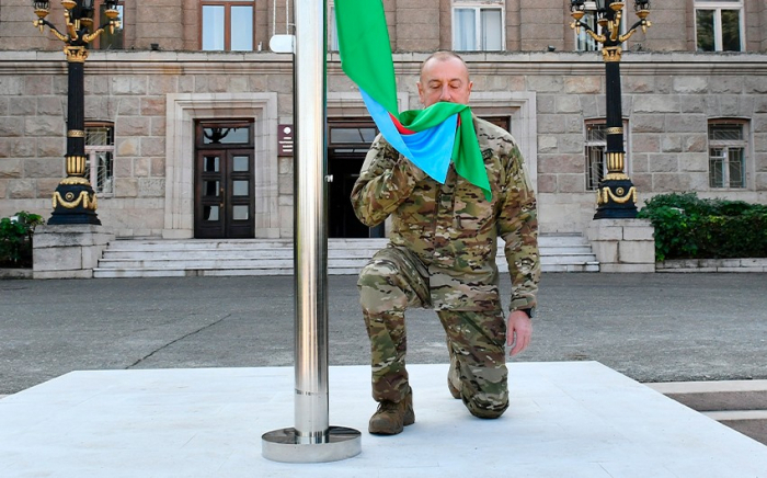   Presidente Ilham Aliyev iza la bandera nacional de Azerbaiyán en la ciudad de Khojavand  