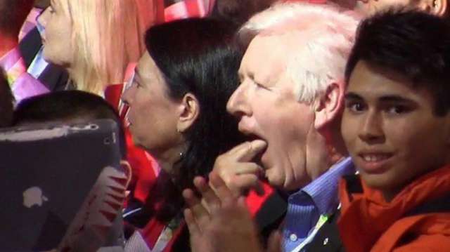 Un membre du parti libéral canadien fait mine de vomir pendant un hommage à Stephen Harper