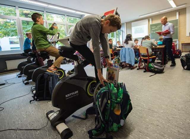 Schüler verbringen Unterricht auf Ergometer