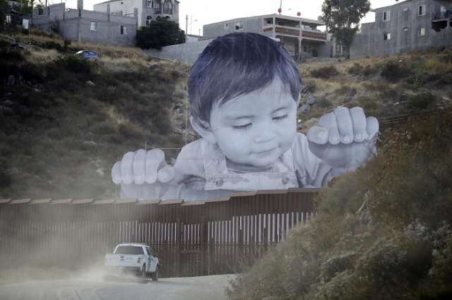 Giant toddler picture appears over Mexico-US border wall