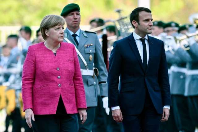 Macron rejects sharing euro debt, pledges EU reforms during meeting with Merkel
