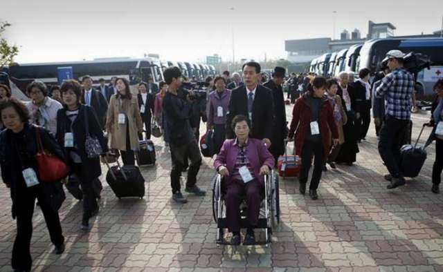 South Koreans cross armed border to meet families in North Torn by war