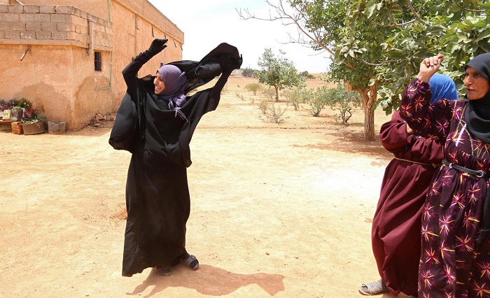 Syrian women pictured throwing off niqabs after their village freed from Isis