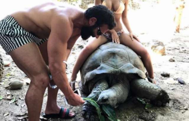 'King of Instagram' under fire for photo of his bikini-clad friend sitting on 100-year-old tortoise
