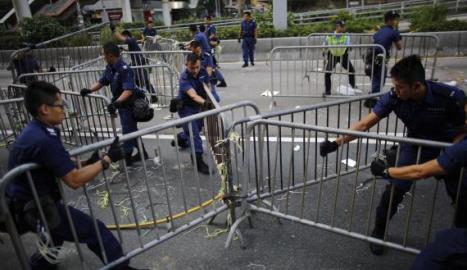 Scuffles erupt in HK business district as hundreds break down protest barriers