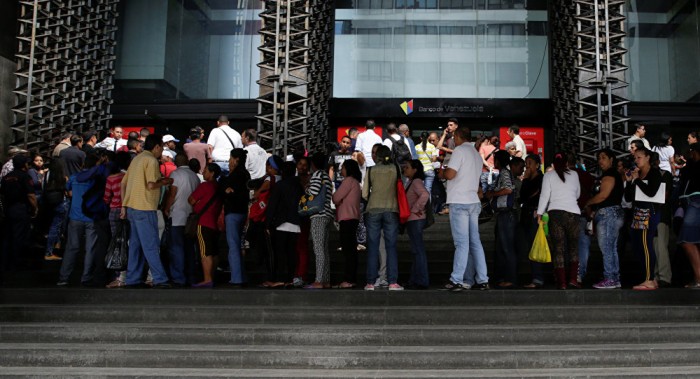 Venezolanos hacen largas colas para depositar billetes de 100 bolívares